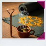 Ayurvedic Detoxification Methods for Holistic Cleansing A coppery tongue scraper, a steaming tea cup, and a yoga mat.